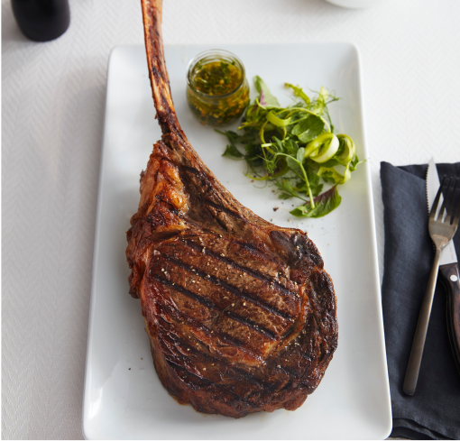 Beef Tomahawk With Side of Vegetables on a Retangular White Plate