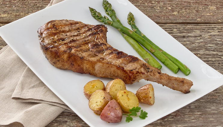 Tomahawk With Asparagus and Roasted Potatoes on a White Plate