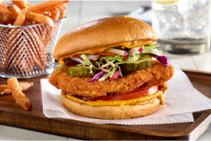 Chicken sandwich with pickles and slaw, with a side of fries