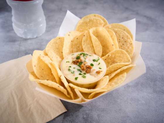 Image of chips with taco queso in a basket.