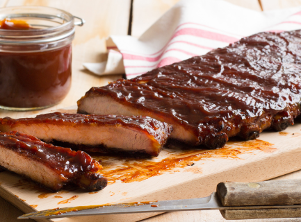 Spareribs glazed with bbq on a wooden board