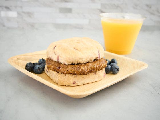 Image of Blueberry Sausage Biscuit on a Plate With Orange Juice.