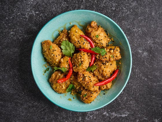 Spicy Honey Garlic Boneless Wings in a blue bowl.