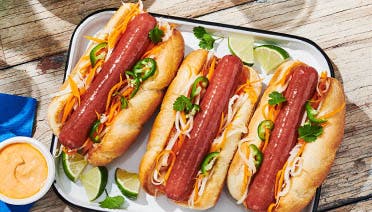 Three Korean slaw and jalapeno hot dogs plate image
