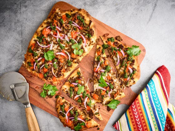 Chimi Steak Flatbread With a Pizza Slicer on a Serving Board