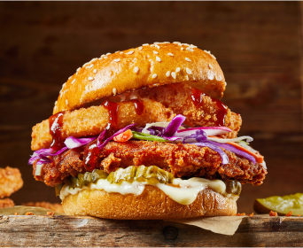 Spicy chicken sandwich with friend onions, pickles and slaw