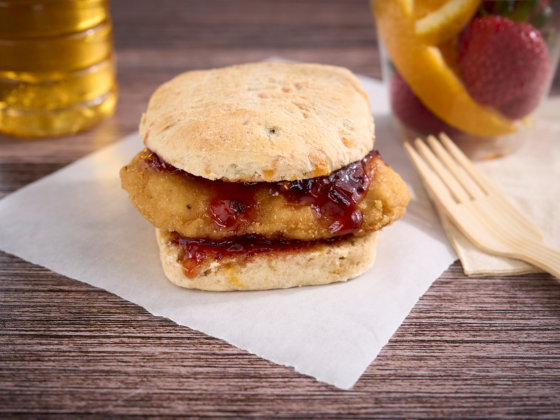 Chicken sandwich with sauce on parchment paper